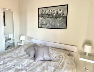 ein Schlafzimmer mit einem Bett mit einem Bild an der Wand in der Unterkunft Casa Al convento in Savigliano