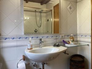 een badkamer met een witte wastafel en een spiegel bij Villa Toscana in Loro Ciuffenna