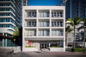 un edificio blanco con palmeras delante en MB Hotel, Trademark Collection by Wyndham, en Miami Beach
