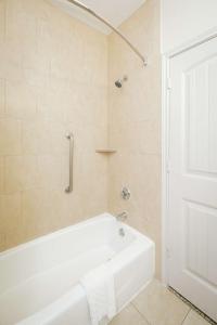 a white bath tub in a bathroom with a shower at Best Western Sugar Land - Richmond in Sugar Land