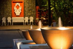 a group of bowls sitting on a table with chairs at Angsana Maison Souvannaphoum Hotel in Luang Prabang