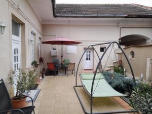 a house with a porch with a boat and an umbrella at Edina Apartman in Sátoraljaújhely