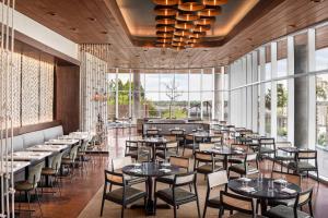 孟菲斯Hyatt Centric Beale Street Memphis的有桌椅和大窗户的餐厅