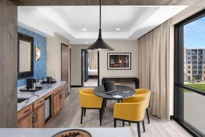 a kitchen and dining room with a table and yellow chairs at Hyatt Centric Beale Street Memphis in Memphis