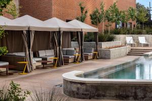 a pool with umbrellas and chairs next to a building at Hyatt Centric Beale Street Memphis in Memphis