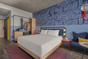 a bedroom with a large white bed and a blue wall at Caption By Hyatt Beale Street Memphis in Memphis