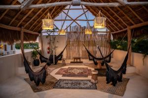 a room with two hammocks in a room with a ceiling at Majaro Tulum in Tulum