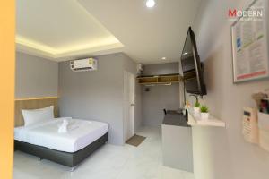 a small bedroom with a bed and a television at Modern Resort in Ban Khlong Khachen