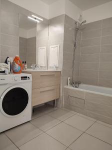 een badkamer met een wasmachine en een bad bij Chambre privée dans un nouvel appartement partagé près de Paris avec parking gratuit in Chevilly-Larue