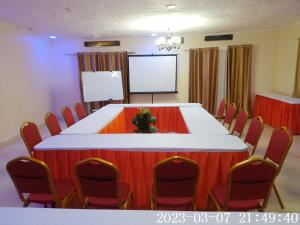 a conference room with a table and chairs and a screen at Comfort Guest House in Kericho