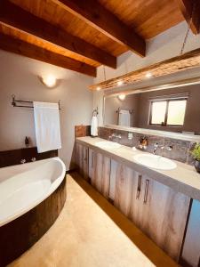 a bathroom with two sinks and a bath tub at Ingwe Bush Lodge in Hoedspruit