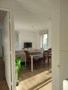een woonkamer met een tafel en stoelen en een bank bij Chambre privée dans un nouvel appartement partagé près de Paris avec parking gratuit in Chevilly-Larue