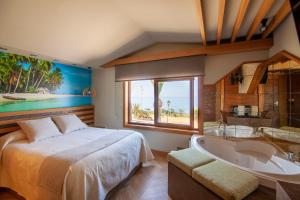 a bedroom with a bed and a tub and a window at Apartamentos El Roqueo in Conil de la Frontera