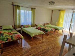 three beds in a room with wooden floors and windows at M&M Bazen resort Goražde in Goražde +54 photos