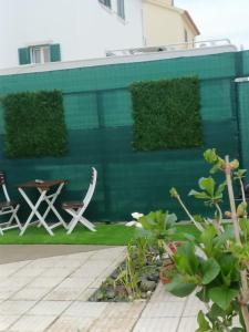 a green wall with two chairs and a table at Casa em Palmela - Setúbal in Palmela