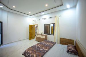 sypialnia z łóżkiem, komodą i lustrem w obiekcie RESIDENCE TERANGA immo luxe w mieście Dakar