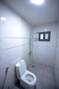 biała łazienka z toaletą i oknem w obiekcie RESIDENCE TERANGA immo luxe w mieście Dakar