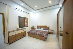 sypialnia z łóżkiem, komodą i lustrem w obiekcie RESIDENCE TERANGA immo luxe w mieście Dakar