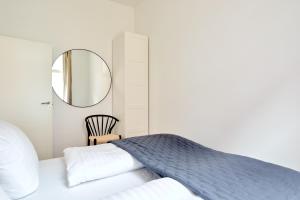 a bedroom with a bed with a mirror and a chair at Great Apt · Near Beach · CPH in Copenhagen
