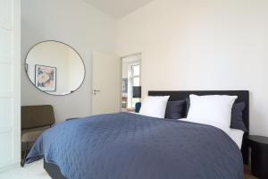 a bedroom with a blue bed and a mirror at Great Apt · Near Beach · CPH in Copenhagen