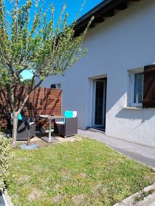 uma mesa e cadeiras num quintal ao lado de um edifício em Sagardi Zolan em Saint-Jean-de-Luz