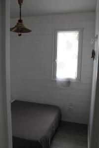 um pequeno quarto com uma cama e uma janela em Sagardi Zolan em Saint-Jean-de-Luz