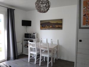 a dining room with a white table and chairs at Sagardi Zolan in Saint-Jean-de-Luz