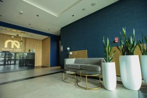 a lobby with a waiting room with two plants at Apartament Gdynia Arena in Gdynia