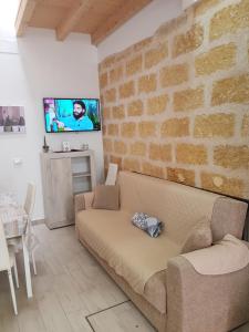 - un salon avec un canapé et un mur en briques dans l'établissement Casa dolce casa, à Partinico