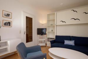 a living room with a blue couch and a tv at Dünenblick Wohnung 17 in Boltenhagen