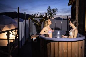 duas mulheres numa banheira de hidromassagem à noite em Alojamientos Casa Ruiz em Archivel