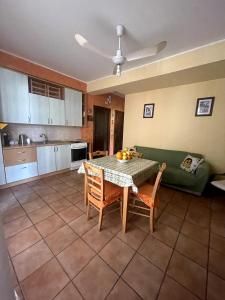 Da Cinzia في Stazzo: غرفة معيشة مع طاولة وأريكة خضراء