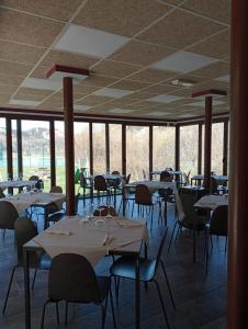 a dining room with tables and chairs and windows at Hotel Rural Rio Molinar in Ranera