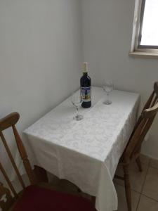 een tafel met een fles wijn en twee wijnglazen bij Apartman Bačić in Vela Luka