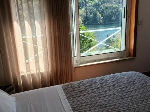 um quarto com uma janela com vista para um rio em Casa de Ribes T2 Vista Fantástica em Rio Caldo