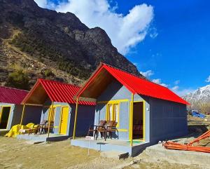 a house with a red roof in front of a mountain at Siramani River Camp in Jispa
