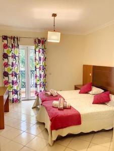 een slaapkamer met een groot bed met rode lakens bij Candyland Apartment in Albufeira