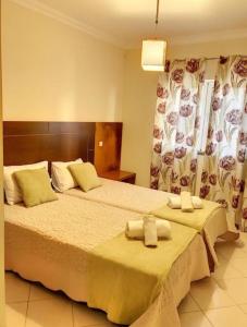 een slaapkamer met 2 bedden en handdoeken bij Candyland Apartment in Albufeira