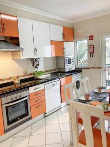 een keuken met witte apparatuur en een tafel met stoelen bij Candyland Apartment in Albufeira