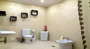 een badkamer met toilet en wastafel en twee televisies bij Candyland Apartment in Albufeira +6 foto's
