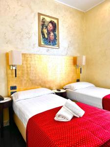 a hotel room with two beds with red sheets at Hotel Fiorella Milano in Milan