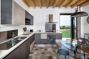 una cucina con tavolo in vetro e piano di lavoro di Villa Balate - Countryside Luxury Experience a Ragusa
