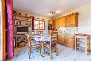 een keuken met een tafel en stoelen en een keuken met een tv bij Le Chatellard - Proche Piste de Ski in Praz-sur-Arly
