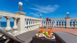 uma mesa com dois pratos de comida numa varanda em Hellenia Yachting Hotel & SPA em Giardini Naxos