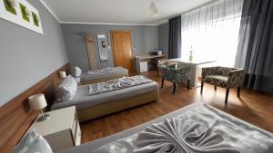 - un salon avec deux lits et une salle à manger dans l'établissement Pension Reiter, à Blomberg