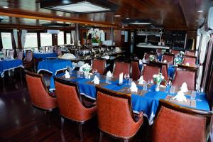 a dining car of a train with blue tables and chairs at Blue Diamond Cruise in Ha Long