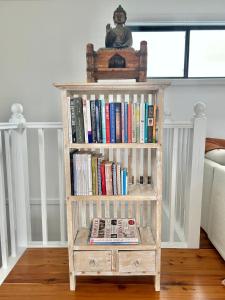 a book shelf filled with books in a room at Long Jetty Lake House in Long Jetty