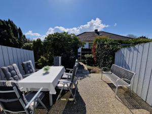 a patio with a table and chairs and a fence at Ferienhaus Butendieksweg 99a in Cuxhaven
