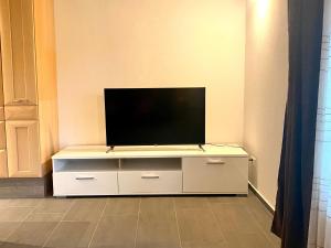 una TV a schermo piatto seduta sopra un armadio bianco di Bienvenue chez les Quadeurs 