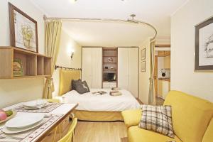 Pokój z łóżkiem i kuchnią z żółtymi krzesłami w obiekcie iFlat Apartment Madonna di Campiglio Adamello 2 w Madonna di Campiglio